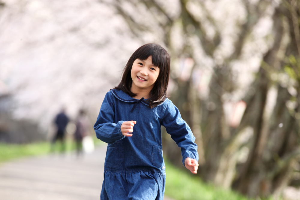 桜並木を走る女の子